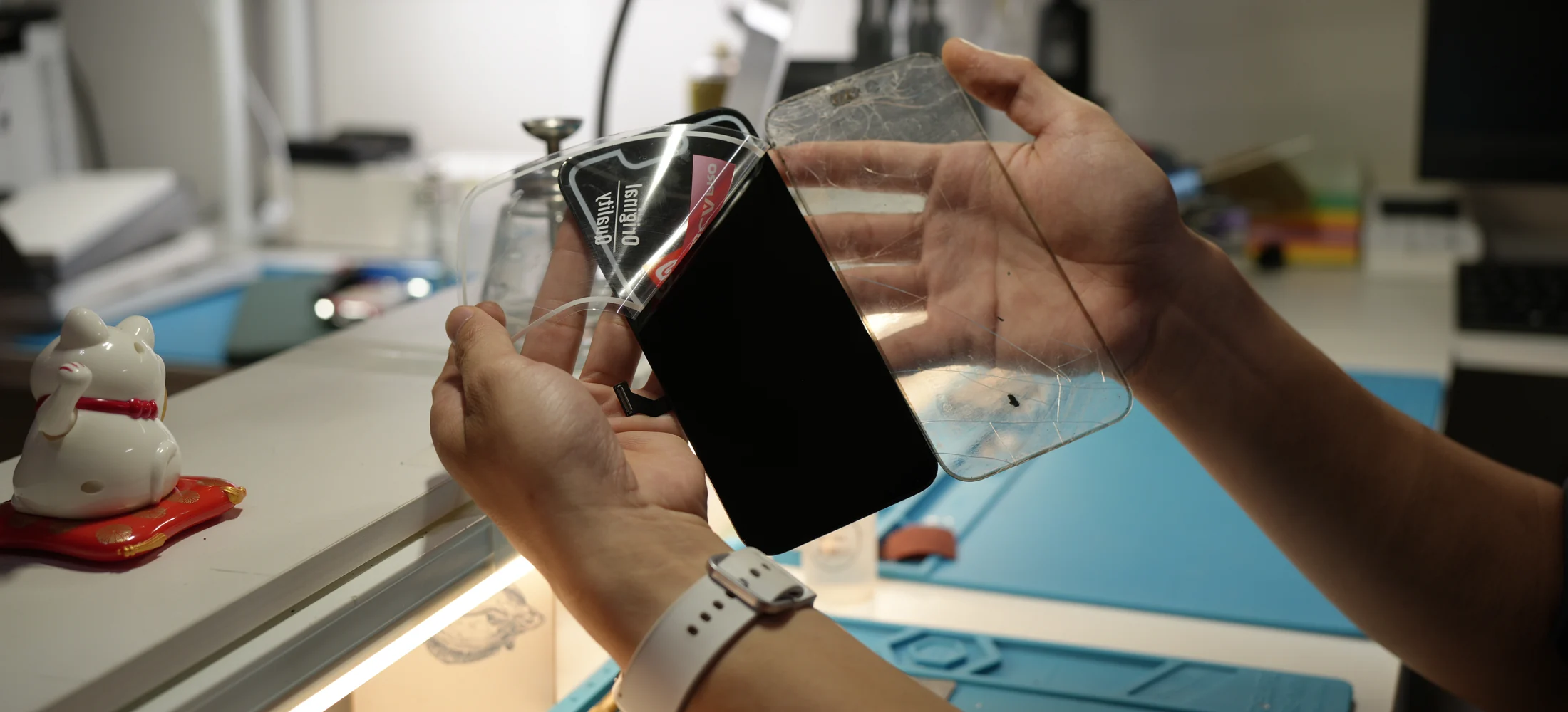 Technicien ScreenFix séparant la vitre cassée d’un écran dans l’atelier