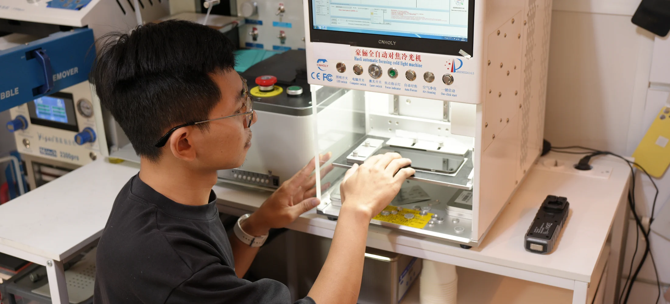 Technicien ScreenFix utilisant une machine de reconditionnement d’écran